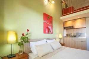 a bedroom with a white bed and a red painting at Syrainas studios in Troulos