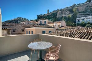 a table and chairs on a balcony with a view at Nalia Suites in Nafplio
