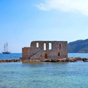 an old building in the middle of the water at plytra house in Plytra
