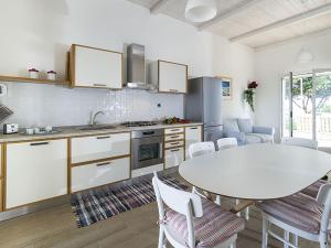 ドンナルカータにあるBelvilla by OYO Villa Muriel Morganaのキッチン(白いテーブル、テーブル、椅子付)