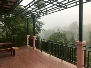 a balcony with a view of a misty forest at Baanphet Sukphrom Wang Nam Khiao in Ban Khlong Ta Sang