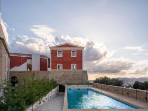 a swimming pool in front of a building at Parador de Ibiza in Ibiza Town