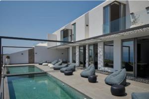 a house with a swimming pool and a building at Teria Collection in Porto Heli