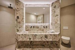 a bathroom with a sink and a mirror and a toilet at Teria Collection in Porto Heli +40 photos