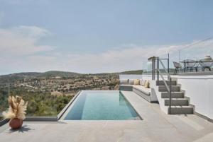 a villa with a swimming pool and a balcony at Teria Collection in Porto Heli