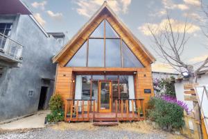 a small wooden house with a triangular roof at Cabin Linggayoni dieng in Diyeng