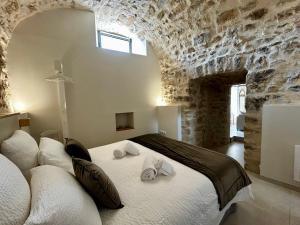 a bedroom with a large bed in a stone wall at Clos des Mouliniers - Gîtes 5 étoiles en Ardèche in Saint-Privat +61 photos