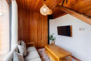 a living room with a couch and a tv at Cabin Linggayoni dieng in Diyeng