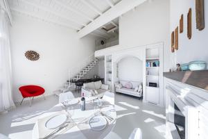 a white living room with a red chair and a table at Bellavista by Whale Homes in Padenghe sul Garda