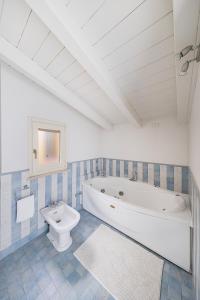 a white bathroom with a tub and a toilet at Bellavista by Whale Homes in Padenghe sul Garda +24 photos