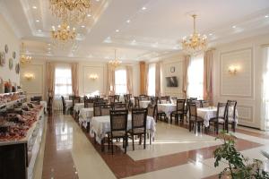 a dining room with tables and chairs and chandeliers at Hotel Asia Khiva in Khiva