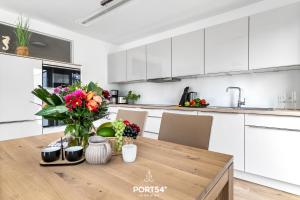 a kitchen with a wooden table with a vase of flowers at Tortuga in Olpenitz