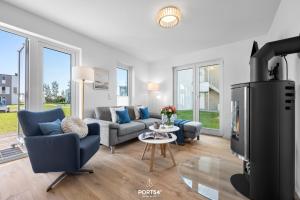 a living room with a couch and chairs and a tv at Tortuga in Olpenitz +27 photos