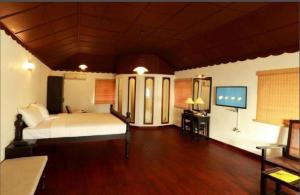 a bedroom with a bed and a flat screen tv at The Heritage Kochi in Cochin +15 photos