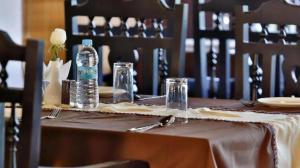 a table with a table cloth with a bottle of water on it at The Heritage Kochi in Cochin