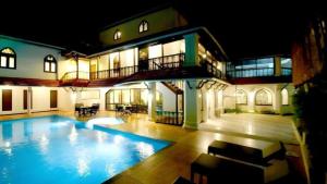 a large swimming pool in a building with a house at The Heritage Kochi in Cochin
