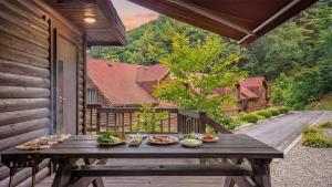 a wooden table on a porch with food on it at Gapyeong Humantown Pension in Gapyeong