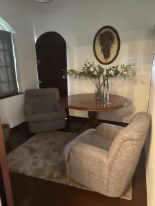 a living room with a table and a chair at Kandy summerhill bungalow in Kandy