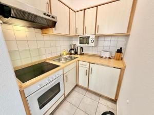 a small kitchen with a sink and a stove at Traumstrand, am Kurpark in Warnemünde