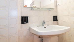 a bathroom with a white sink and a mirror at S'Archittu Sunset House in S'archittu Cuglieri +25 photos