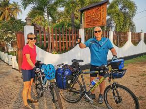 a man and a woman standing next to their bikes at Inpan's beach resort Batticaloa in Batticaloa
