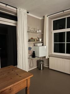a living room with a table and a window at Rinkenæshus Das kleine Zimmer in Gråsten