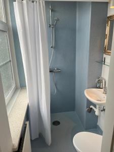 a bathroom with a shower curtain and a sink at Rinkenæshus Das kleine Zimmer in Gråsten
