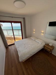a bedroom with a bed and a view of the ocean at Lev Yam Suite in Netanya