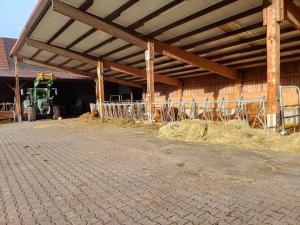 a barn with hay and a tractor in a building at Ferienbauernhof Brandt in Klein-Bieberau