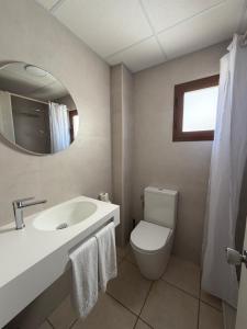 a bathroom with a toilet and a sink and a mirror at Apartamentos Tramuntana in San Antonio +16 photos