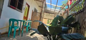 a patio with two chairs and a plant in front of a house at Wallace and Gromit's in Siquijor +5 photos
