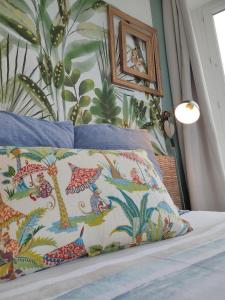 a bedroom with a bed with a tropical wallpaper at Le toit de Veules - Proche Mer - Veules les Roses in Veules-les-Roses