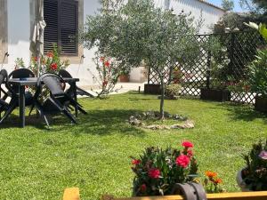 a garden with a table and chairs and flowers at Le Case Al Quadrato Residence in Syracuse +32 photos