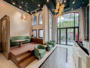 a waiting room with green chairs and a table at CityHouse TERA The S in Ho Chi Minh City