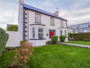 a white house with a red door and a yard at San Antonio in Dungloe