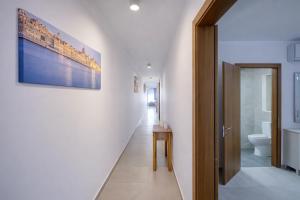 a hallway of a bathroom with a toilet and a painting at Modern 3-bedroom apartment Pieta in Tal-Pietà +30 photos