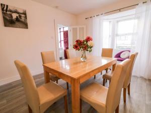 a dining room table with chairs and a vase of flowers at San Antonio in Dungloe