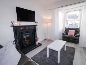 a living room with a fireplace with a couch and a tv at San Antonio in Dungloe