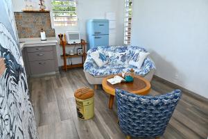 a living room with a couch and a table at Cottage Vanda in Le Moule