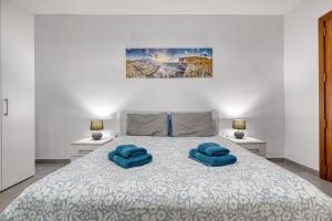 a bedroom with a bed with two blue towels on it at Modern 3-bedroom apartment Pieta in Tal-Pietà