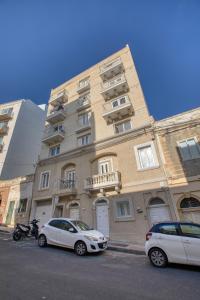 two cars parked in front of a building at Modern 3-bedroom apartment Pieta in Tal-Pietà