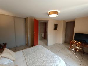 a bedroom with a bed and a flat screen tv at Chambre D’hôtes Parc Johan in Chauffailles