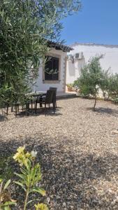 a patio with a table and a bench in front of a house at Le Case Al Quadrato Residence in Syracuse