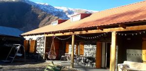a building with a table and chairs in front of a mountain at Sno House in Kazbeg in Sno