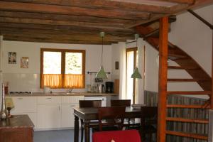 een keuken en eetkamer met een tafel en een trap bij Liabaquet Gîtes in Sarlande