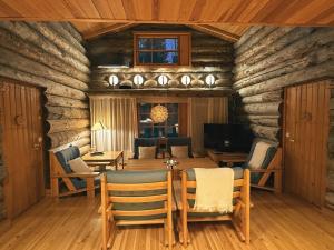 a log cabin living room with a table and chairs at KunnonKolo in Luosto