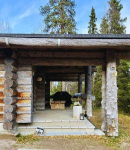 a log cabin with a table in the doorway at KunnonKolo in Luosto