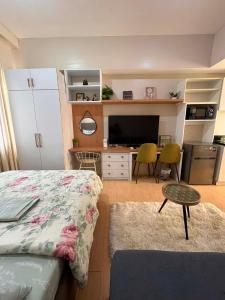 a bedroom with a bed and a desk with a television at Sunvida Tower - Cebu Stay Rental in Dita