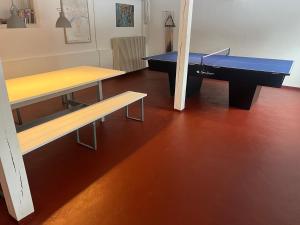 a ping pong table and a bench in a room at Rinkenæshus Hytte A in Gråsten +5 photos