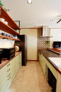 a kitchen with a refrigerator and a counter top at KOGUMA AKIRUNO villa in Akiruno